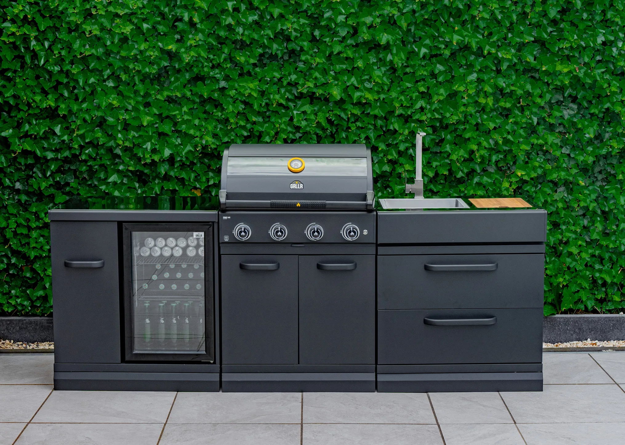 Grllr modular outdoor kitchen featuring high-performance 4-burner grill, integrated beverage cooler, and stainless steel sink station, Roberts Leisure Isle of Man.