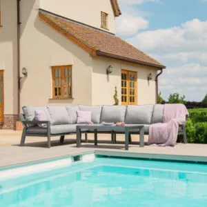 Maze New York Aluminium Corner Sofa Set in Dove Grey with matching coffee table on a wooden deck beside a swimming pool