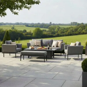Luxury Pulse 3 seat all-weather outdoor fabric sofa and dining set in Zinc Grey with quick-dry cushions, styled on a stone patio overlooking the countryside.