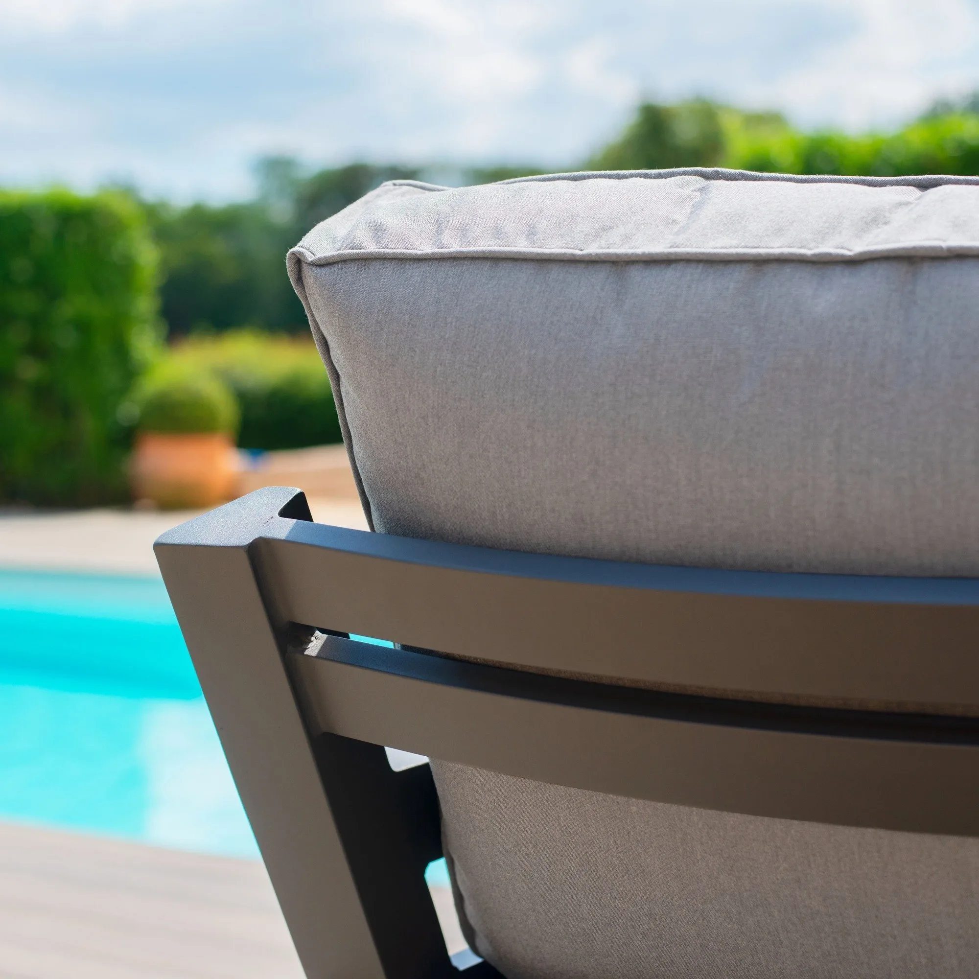 Close-up of the dark slatted aluminium backrest and thick dove grey fabric cushion on the Maze New York Corner Sofa Set.