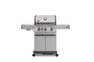 A direct front view of a stainless steel Primeliner S3 gas barbecue grill featuring a closed lid with an integrated temperature gauge, four control knobs, dual side shelves, and a two-door storage cabinet on wheels.