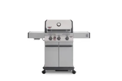 A direct front view of a stainless steel Primeliner S3 gas barbecue grill featuring a closed lid with an integrated temperature gauge, four control knobs, dual side shelves, and a two-door storage cabinet on wheels.