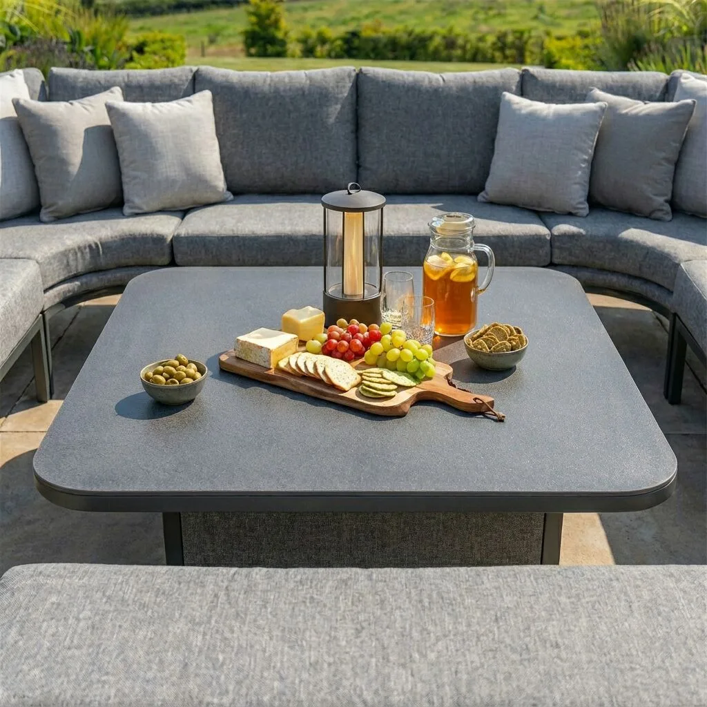 Close-up of the versatile adjustable table included with the Maze - Outdoor Fabric Pulse U Shape Corner Dining Set with Rising Table - Zinc Grey, styled with food and drinks at Roberts Leisure, Isle of Man.