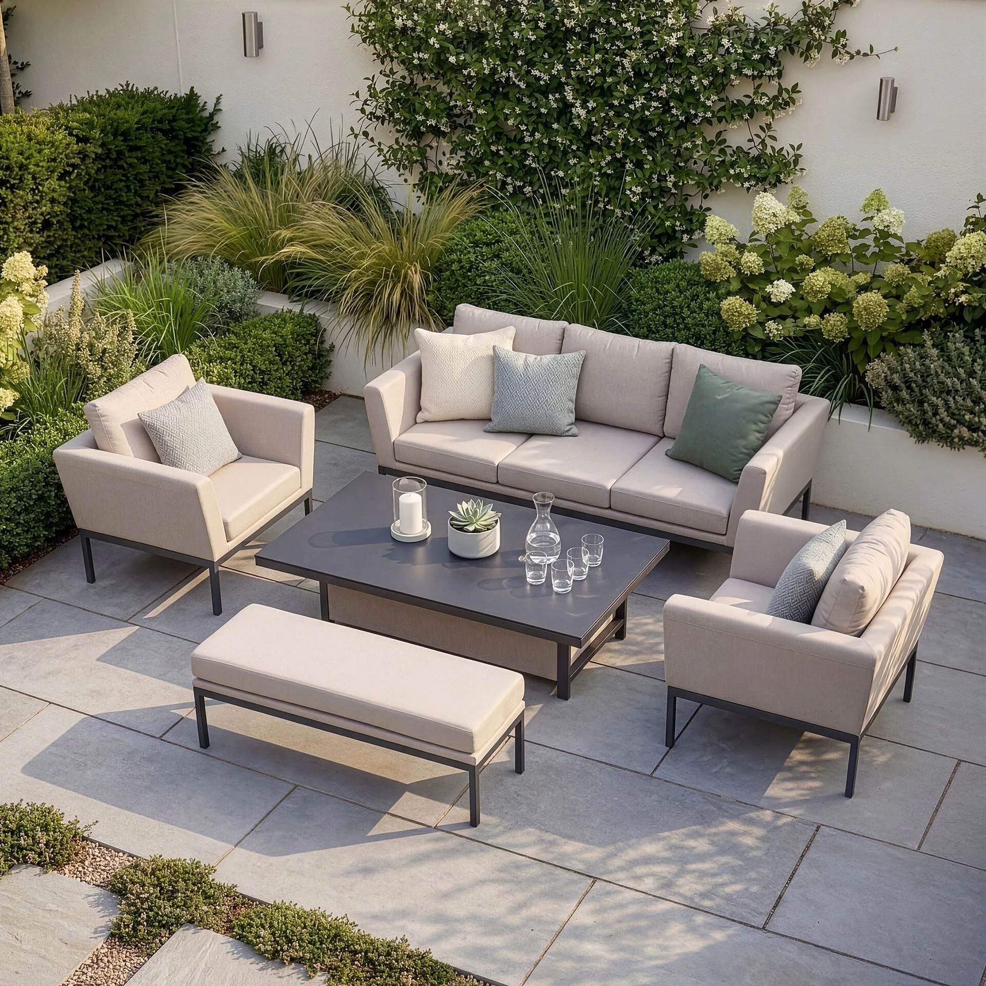 The complete Maze Pulse outdoor fabric sofa and bench set in Oatmeal, featuring the lock-in table raised for dining on a sunlit patio.