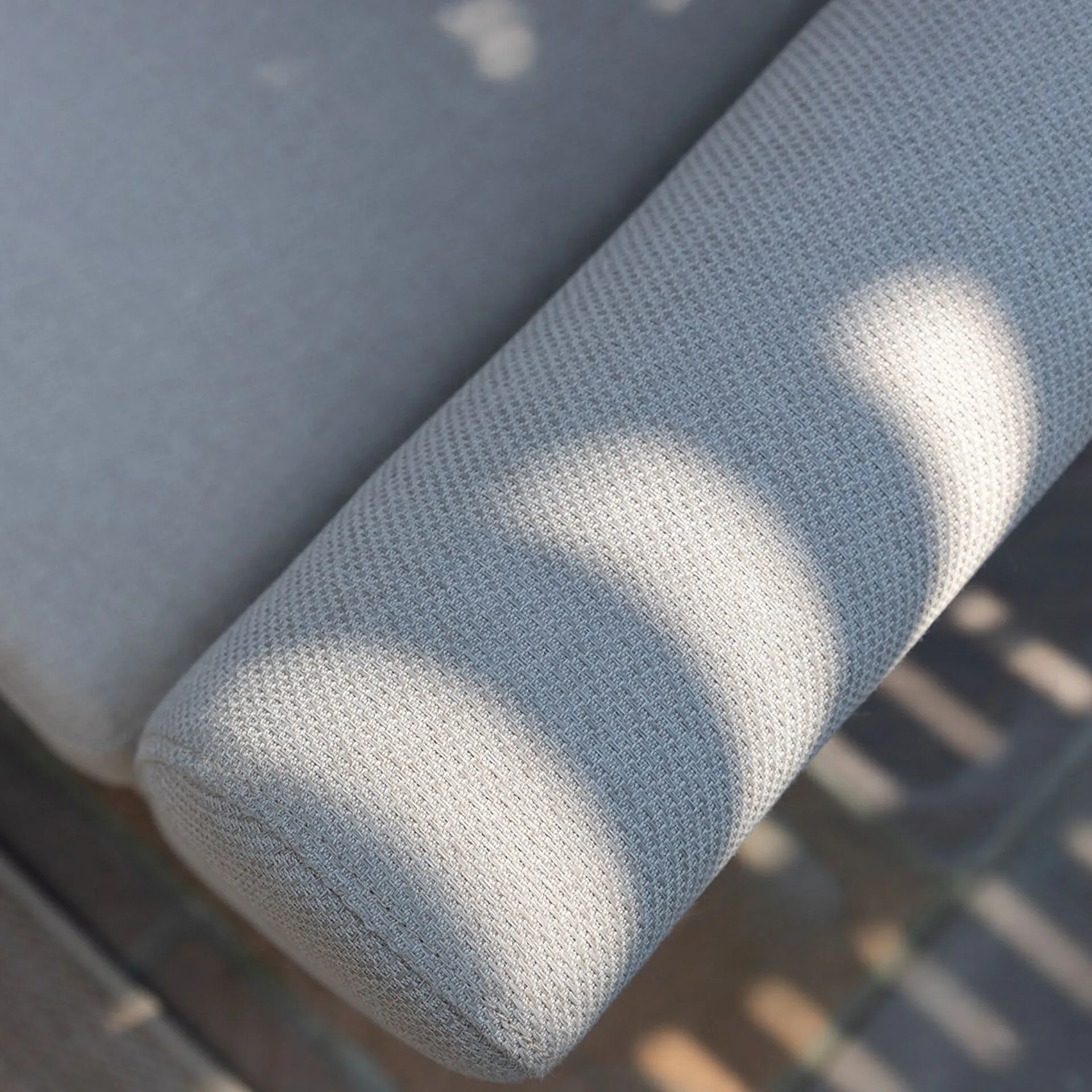 Sunlight highlighting the durable, all-weather Oatmeal fabric weave on the armrest of the Maze Pulse 3-seater garden sofa.