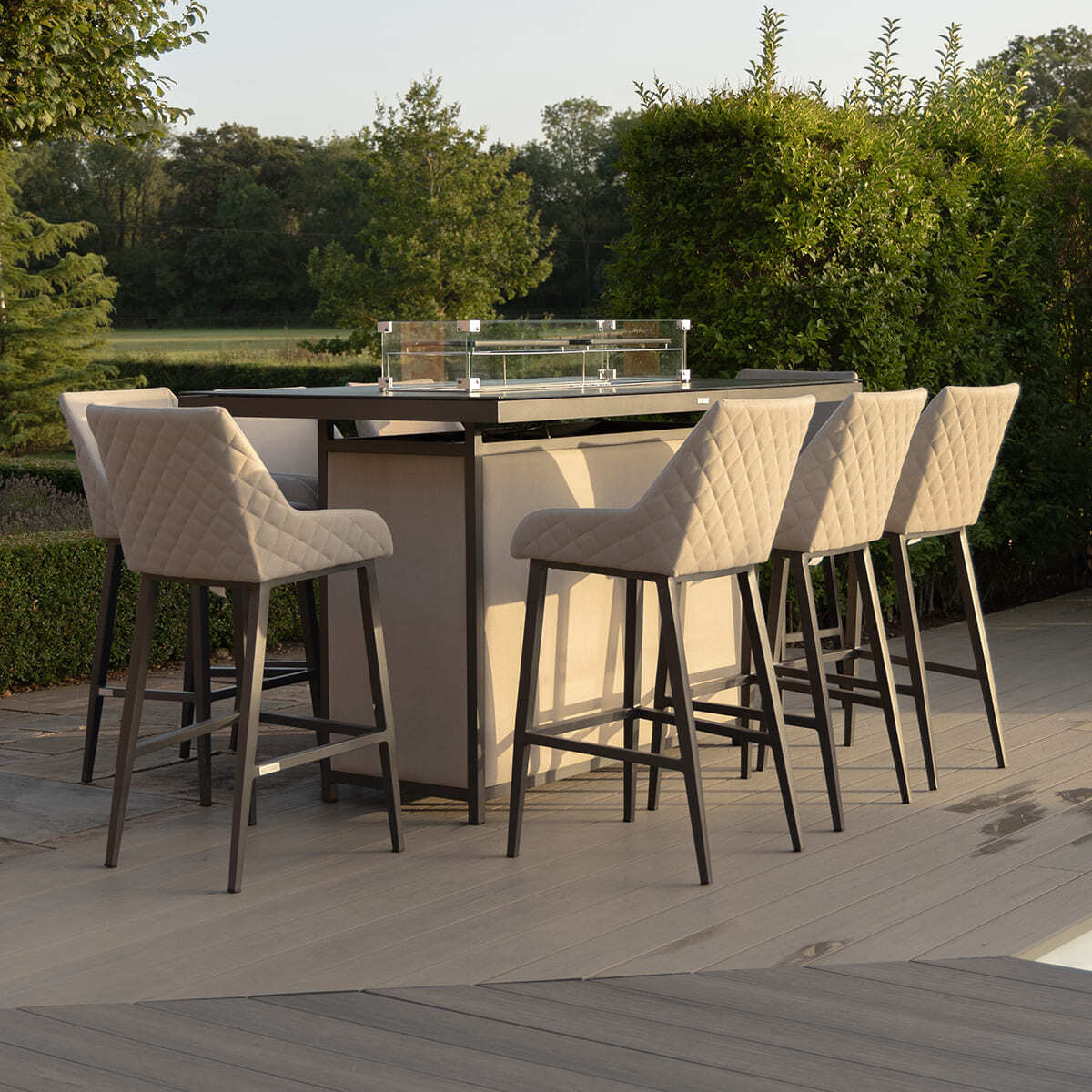 The Maze - Outdoor Fabric Regal 8 Seat Rectangular Bar Set Latte with café frame positioned elegantly on a stone patio beside a pool, featured at Roberts Leisure, Isle of Man.